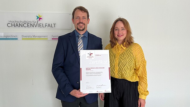 Bild mit Sarah Peters, Leitung Hochschulbüro für ChancenVielfalt und Zentrale Gleichstellungsbeauftragte, und Björn Klages, Referent für den Familienservice, mit dem Zertifikat 