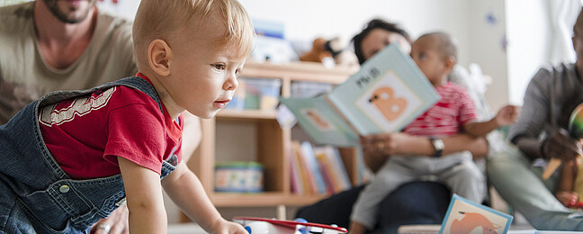 Kinder und Erzieher*innen spielen in der Kita